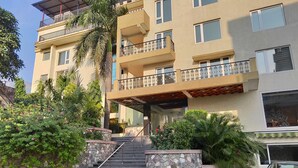 Un edificio de varios pisos con una escalera de piedra que lleva a un balcón.