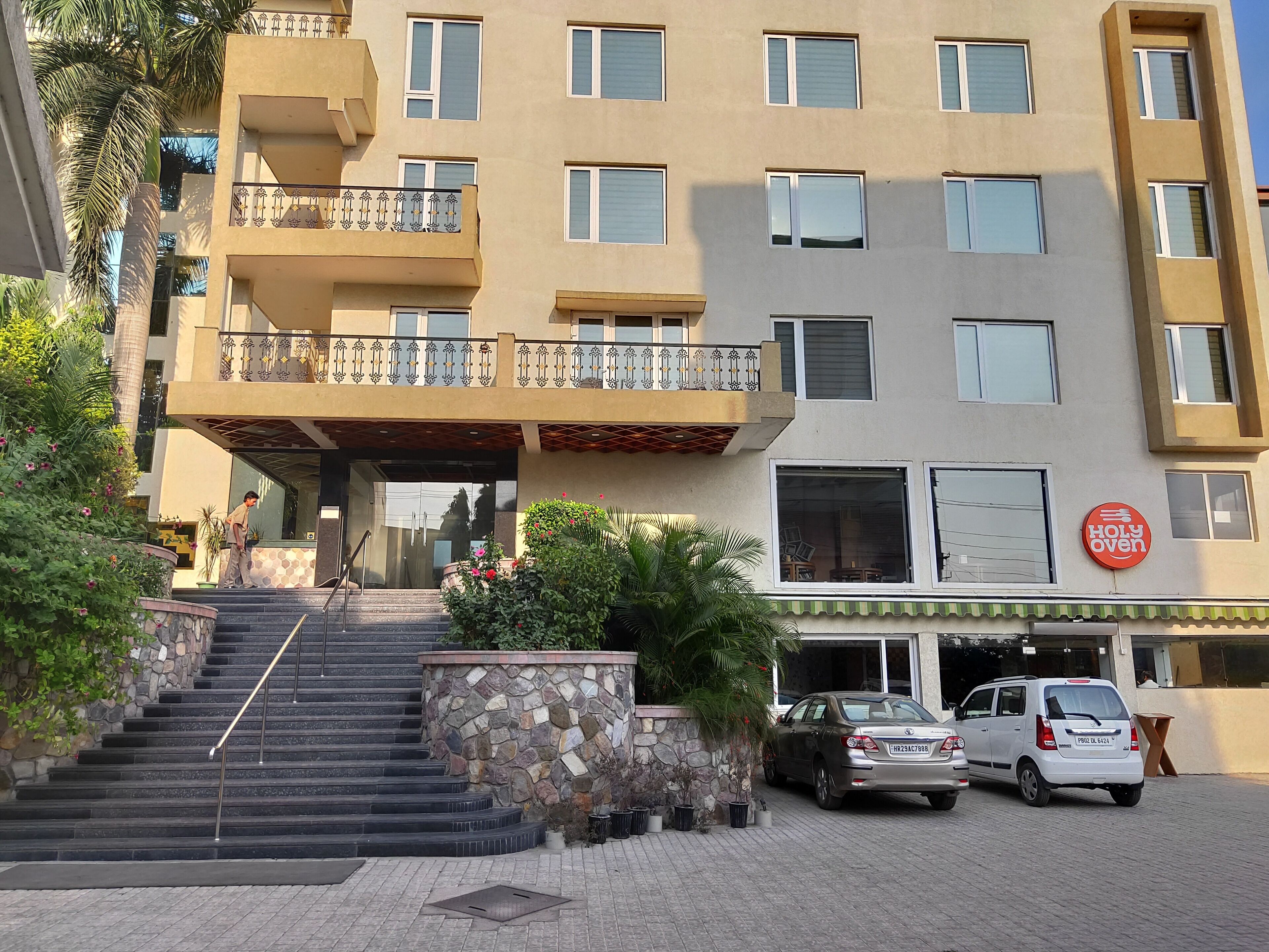 Un edificio de varios pisos con una escalera de piedra que lleva a una entrada con reja.