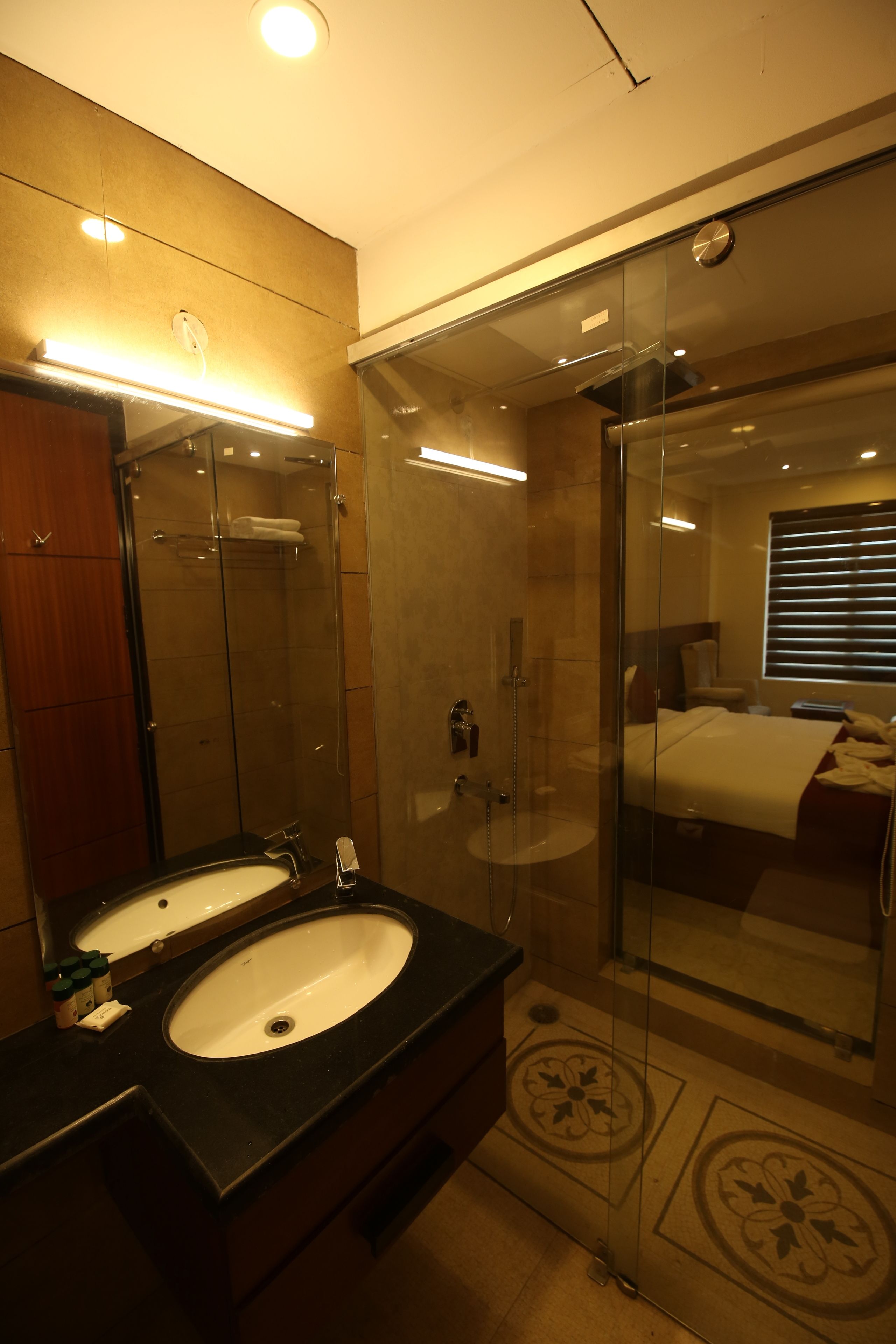 A modern bathroom with a glass-enclosed shower, two sinks, and a large mirror.
