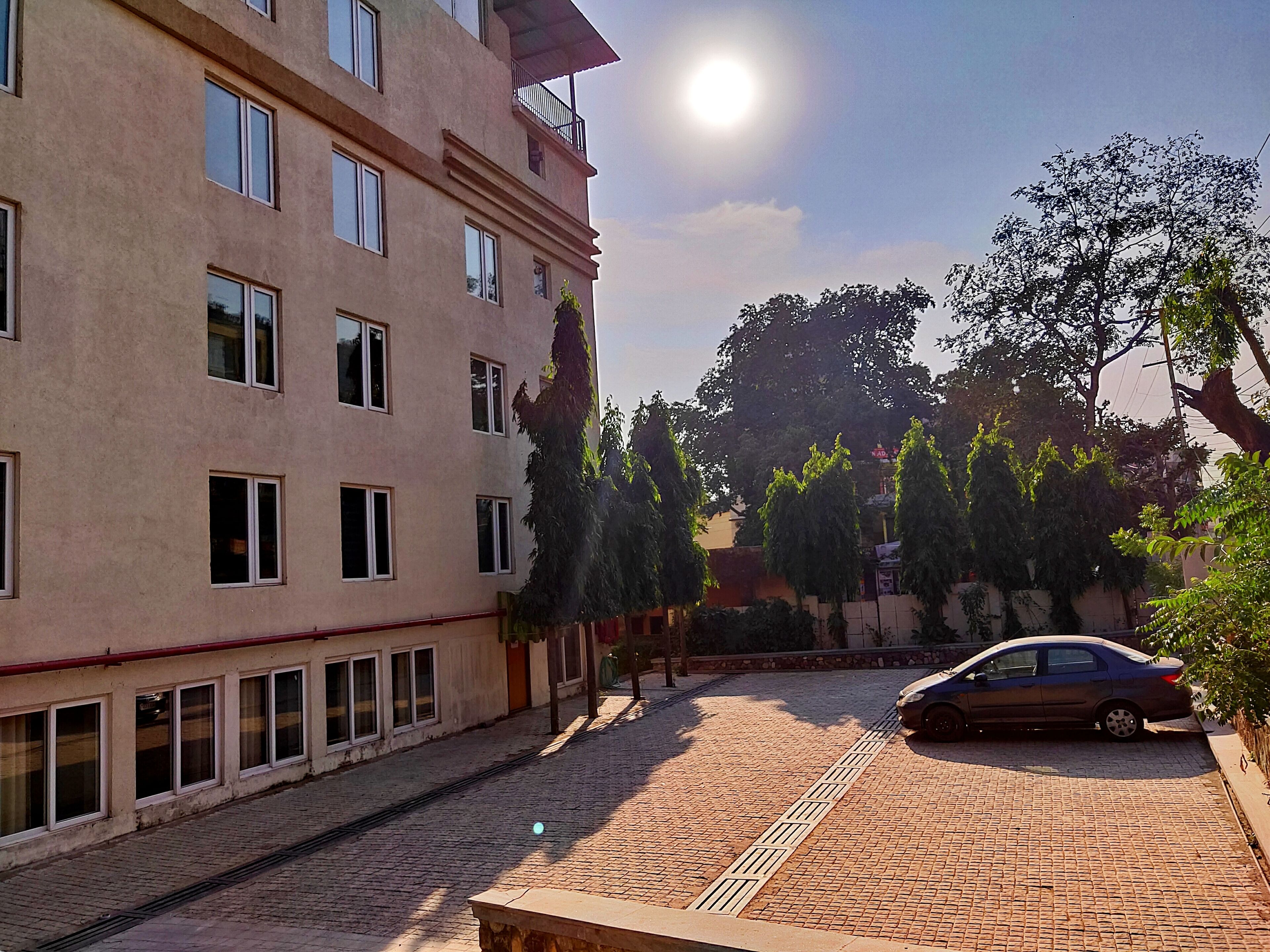 A building with multiple windows and a car parked in front.