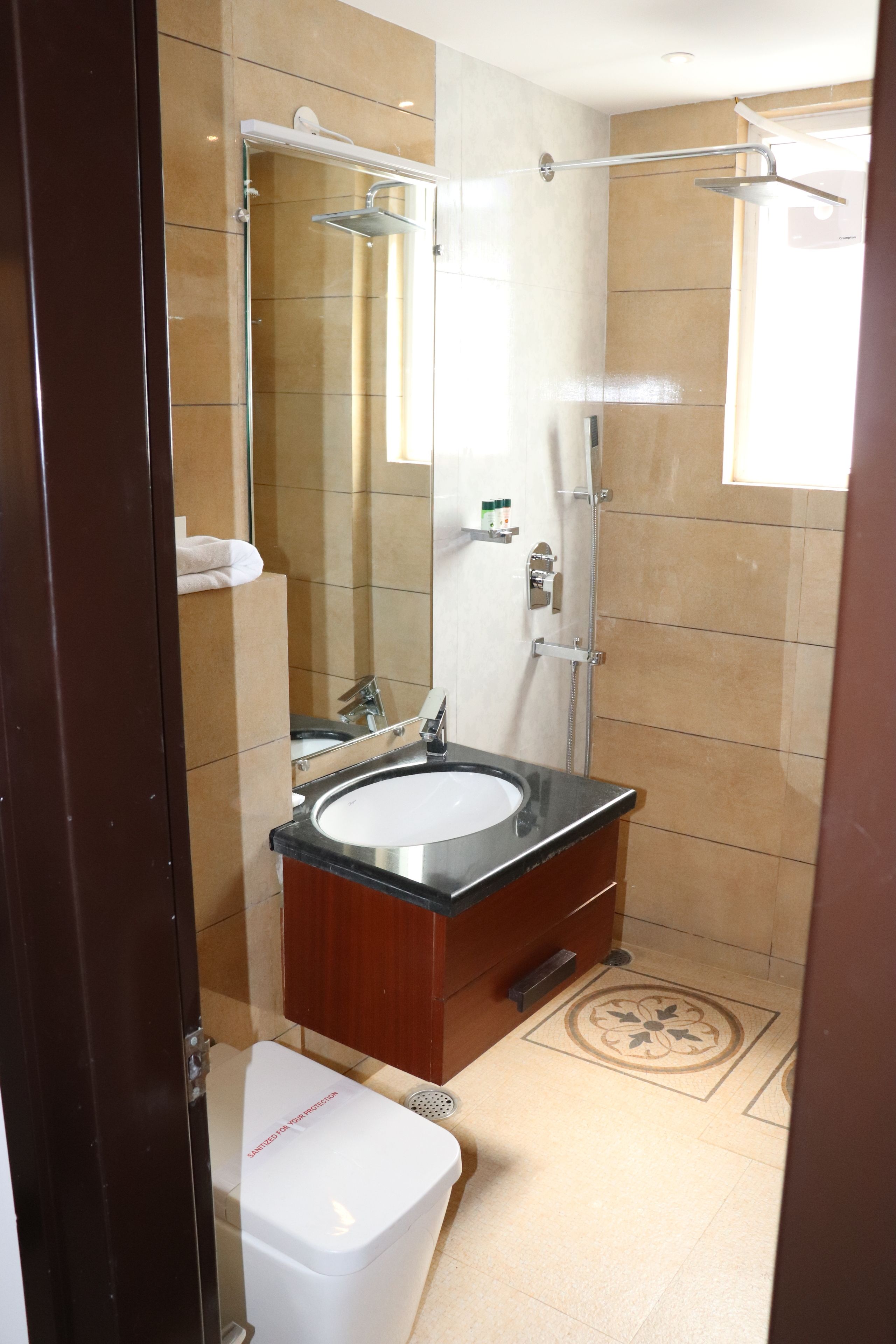 A bathroom with a glass-enclosed shower, a sink, and a toilet.