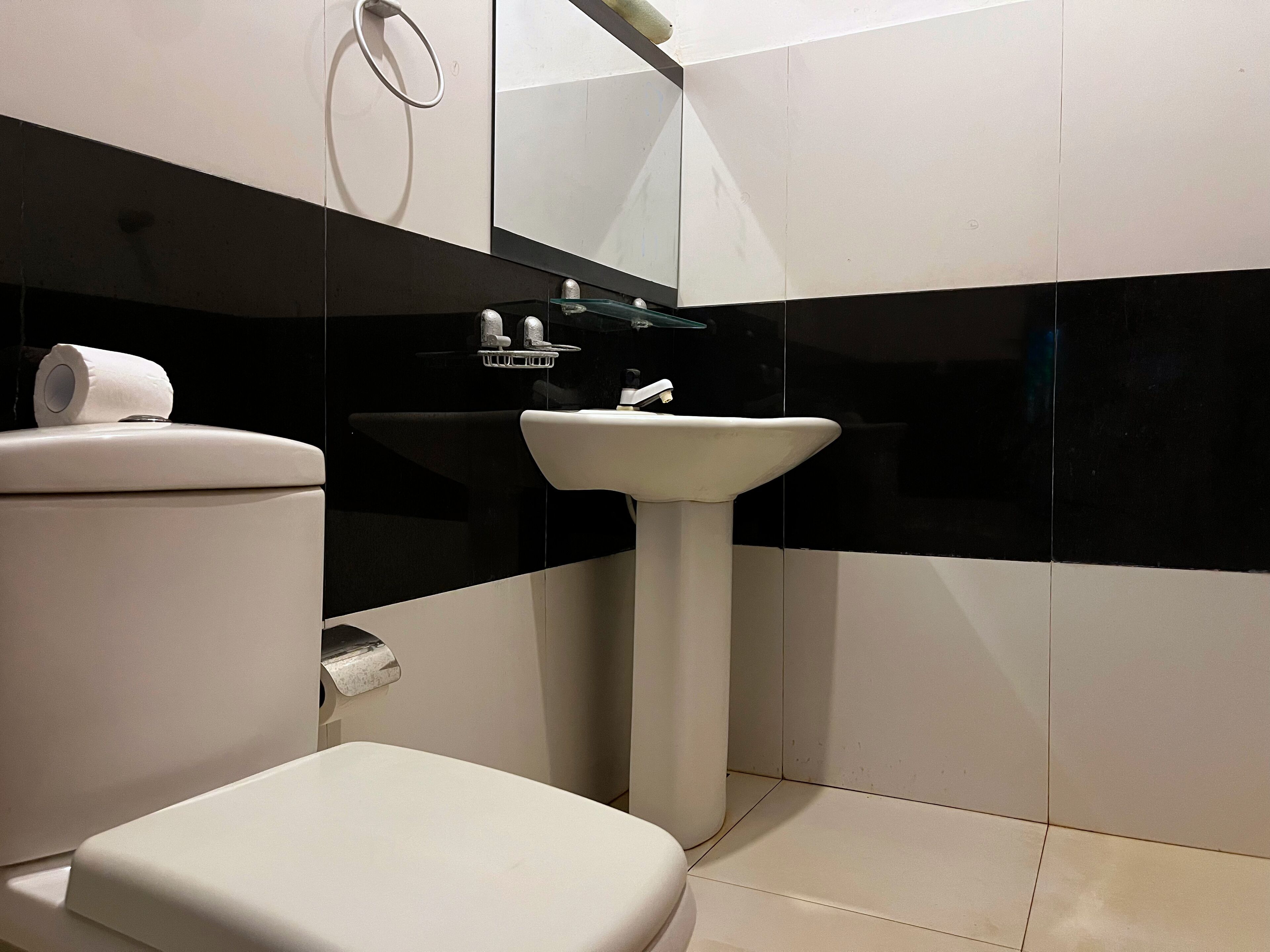 Ein Badezimmer mit Toilette, Waschbecken und Spiegel.