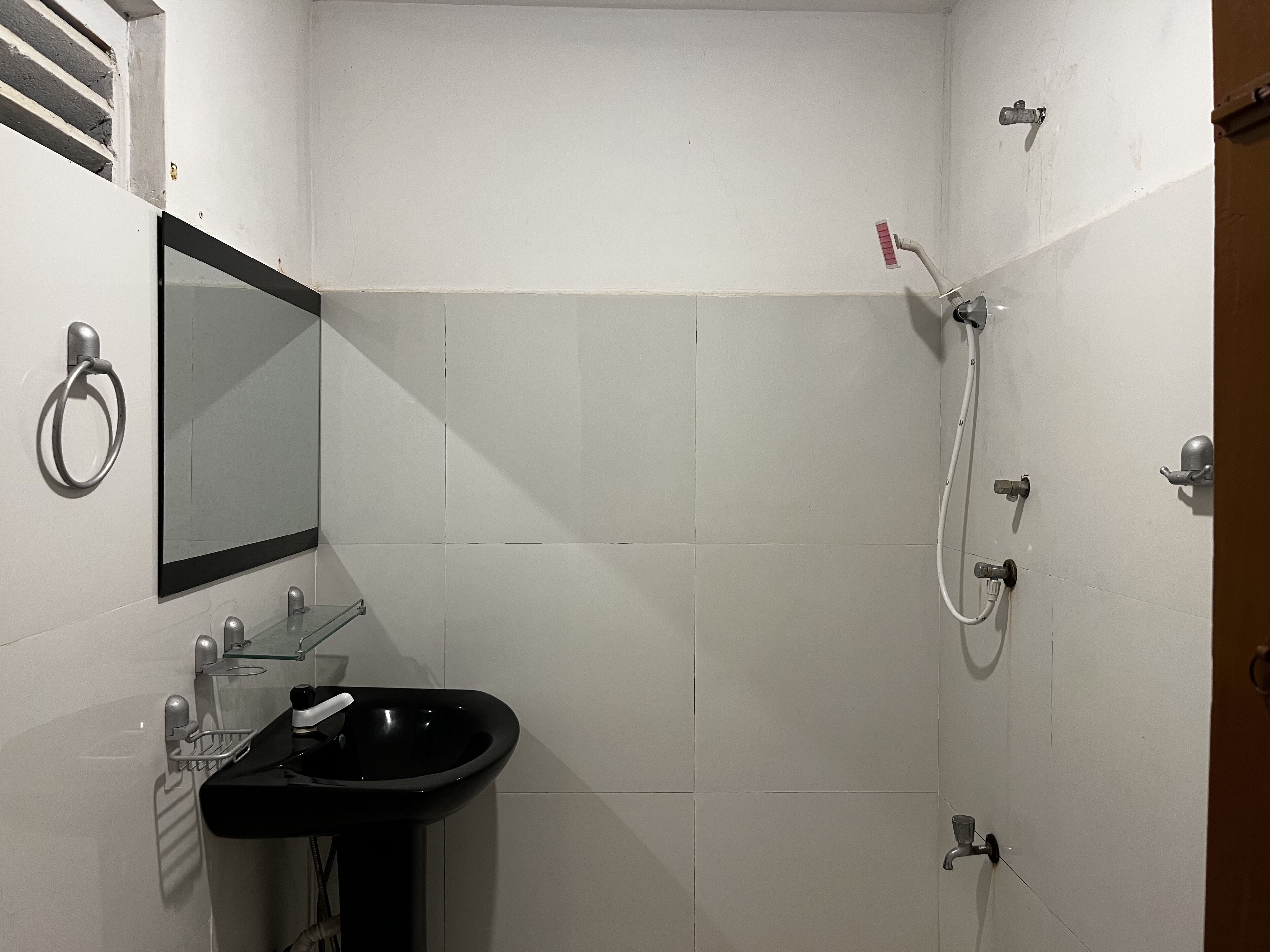 A bathroom with a black sink, a mirror, and a shower.