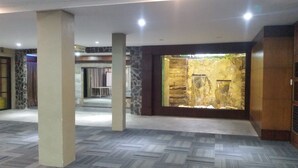A spacious lobby with a stone wall and a water feature. - Casa Verde Hotel & Events Center (Imus)