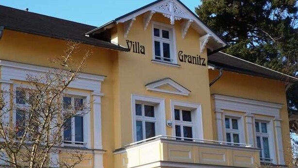 Ein gelbes Gebäude mit dem Schriftzug "Villa Granitz" auf der Fassade.