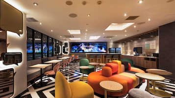 A modern interior with seating, a bar area, and a television screen.