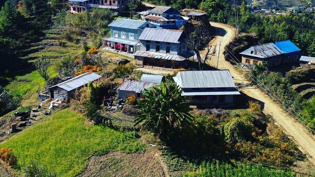 A rural village with houses, terraced fields, and a mountain backdrop. - Mount Mahabharat Homestay (Dhunkharka)