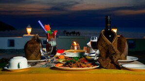 A table set for dinner with a view of the ocean at dusk. - Ocean Blue Ngwe Saung Beach Hotel (Ngwe Saung)