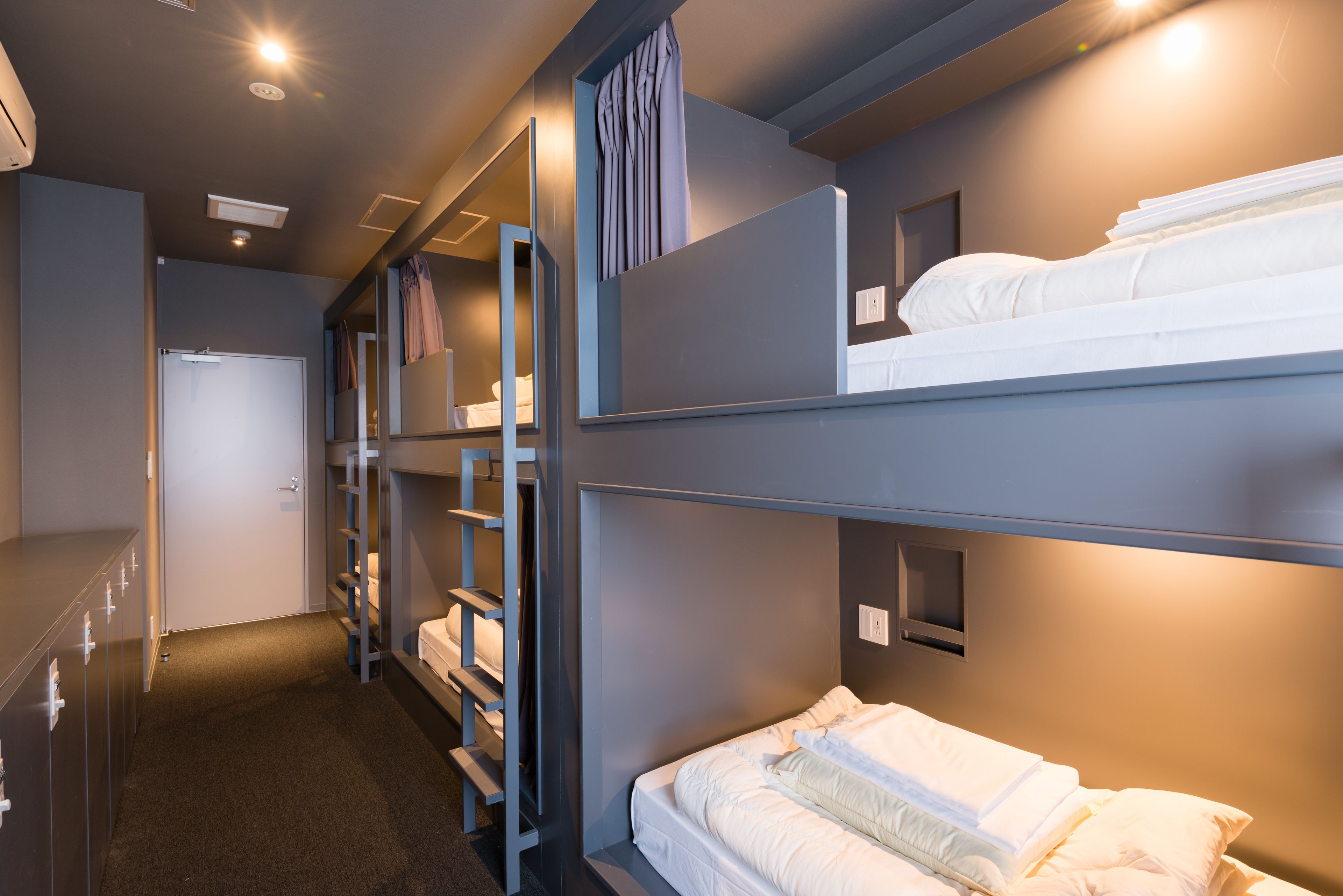A bunk bed room with a wardrobe and a door.