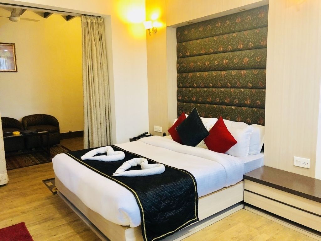 Quarto de hotel com uma cama, uma escrivaninha e uma cadeira.