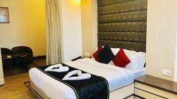 A hotel room with a bed, a desk, and a chair.