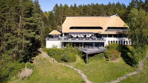 Ein modernes Gebäude mit flachem Dach, umgeben von dichtem Wald.