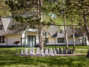 A chessboard set outdoors with a building in the background.