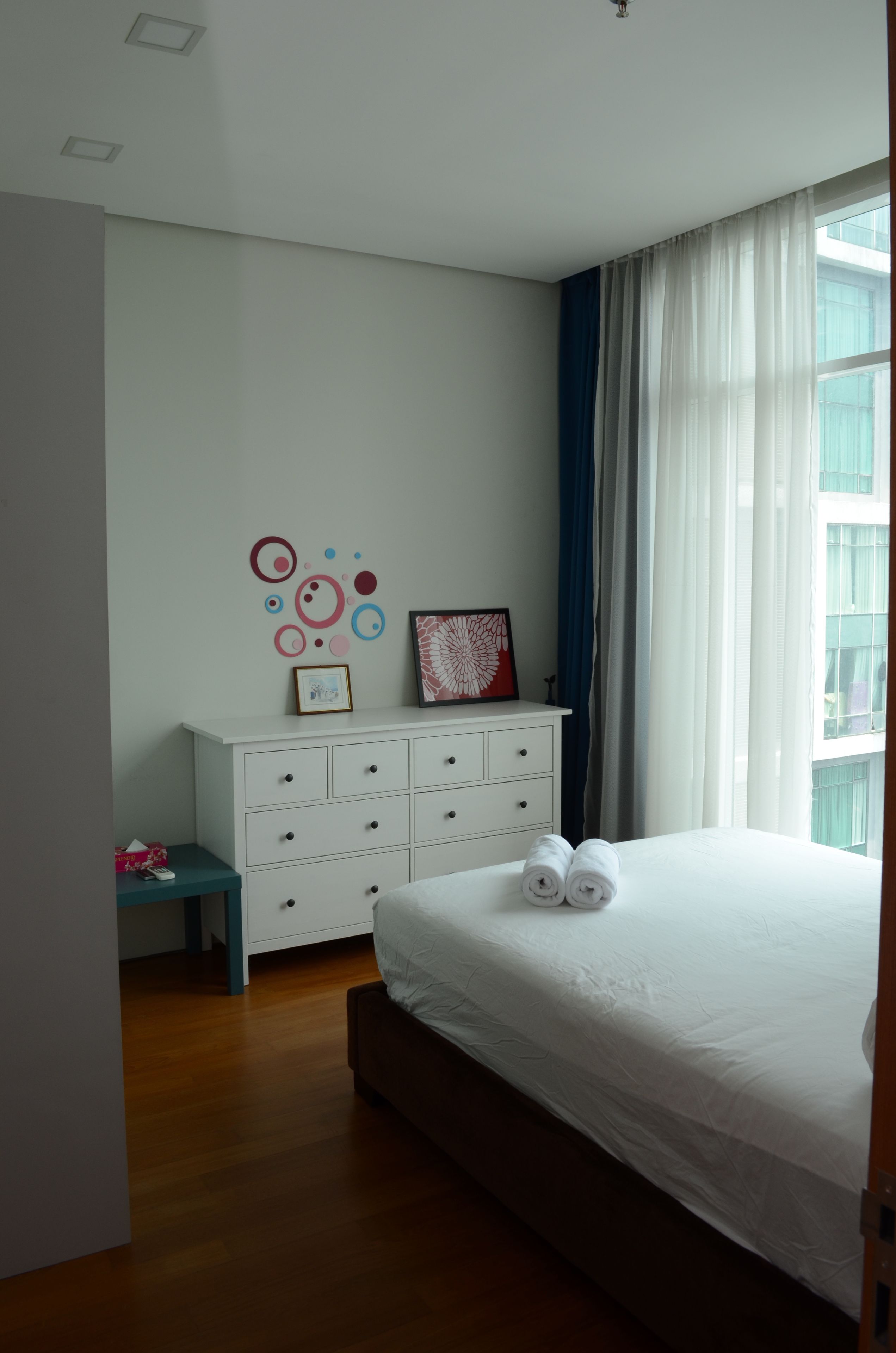 Ein Schlafzimmer mit einem Bett, einem Schminktisch und einer Wand mit Dekorationen.