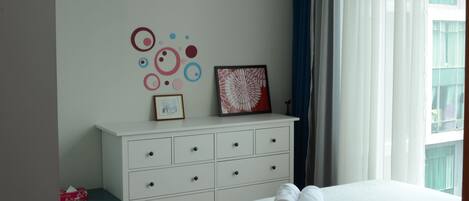 Un dormitorio con cama, cómoda y una pared decorada con arte.