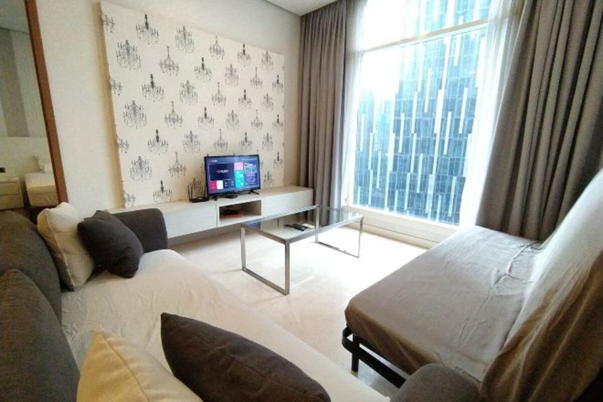 A modern living room with a sofa, a coffee table, and a TV on a stand.