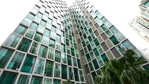 A tall, modern building with a grid of windows and a reflective glass facade.