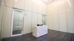 A modern reception area with a marble counter and glass doors.