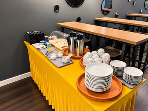 A buffet setup with a yellow table, various food items, and a coffee station. - Seeds Hotel Ampang Point (Ampang)