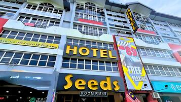 A hotel with a prominent "HOTEL" sign and a "SEEDS" sign below it.