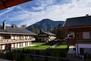 A traditional chalet-style building with a wooden facade, a balcony, and a view of a mountain. - Bodenschneid Suites Rottach-Egern - Bodenschneid Suites Wallbergblick (Rottach-Egern)