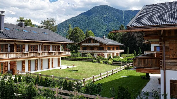 A traditional chalet-style building with a wooden facade, a balcony, and a well-maintained garden. - Bodenschneid Suites Rottach-Egern - Bodenschneid Suites Wallbergblick (Rottach-Egern)