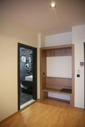 A room with a wooden bench, a mirror, and a sink. - METRO CITY APARTMENTS (Batumi)
