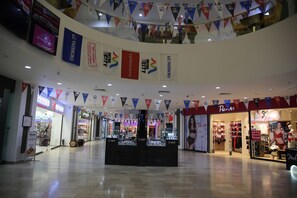 A shopping mall interior with various stores, including a jewelry kiosk and a lingerie store. - METRO CITY APARTMENTS (Batumi)