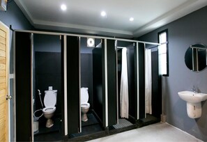 Ein modernes Badezimmer mit Glasabtrennung, Waschbecken und Spiegel.