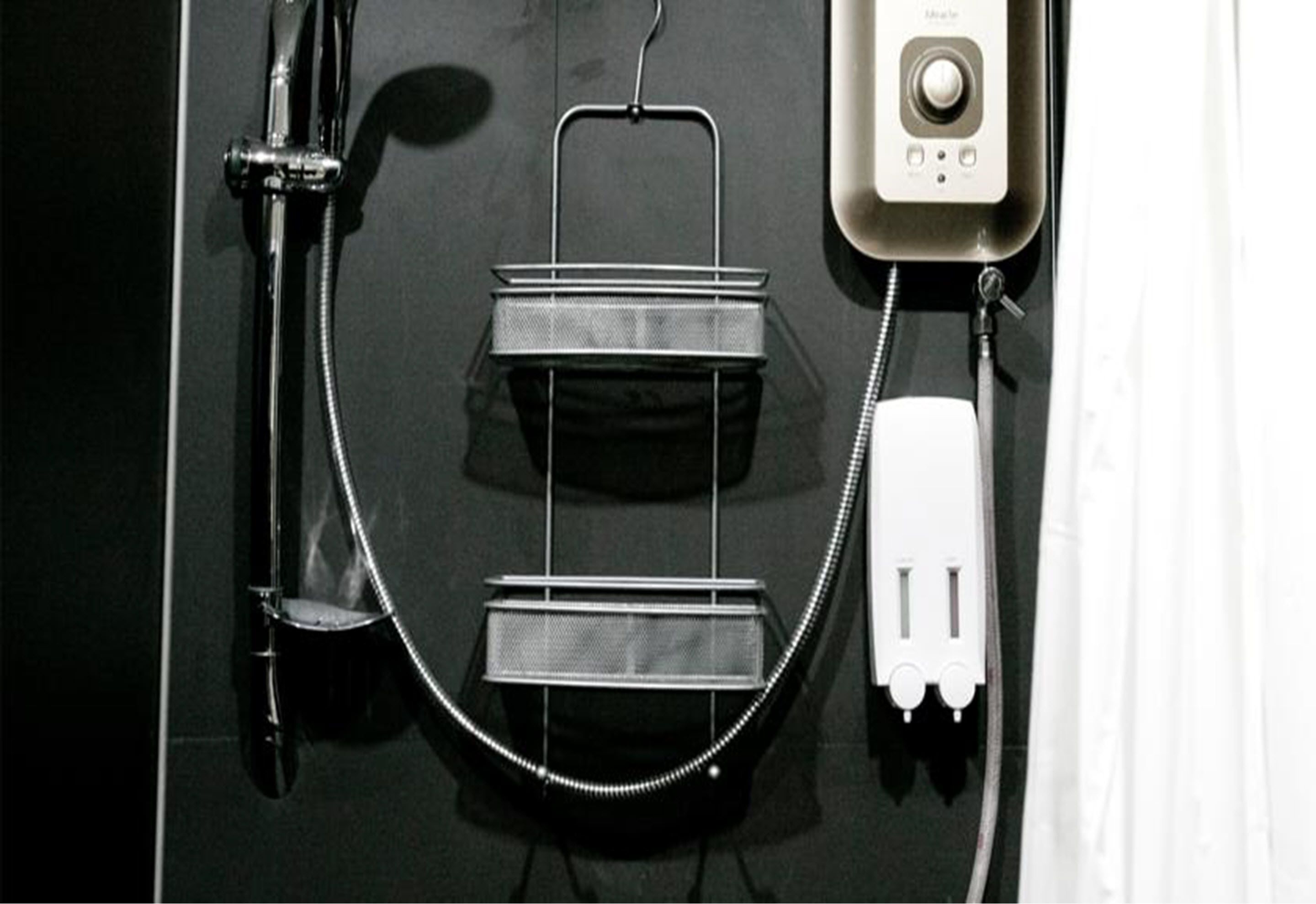 A bathroom with a shower, a towel rack, and a telephone.