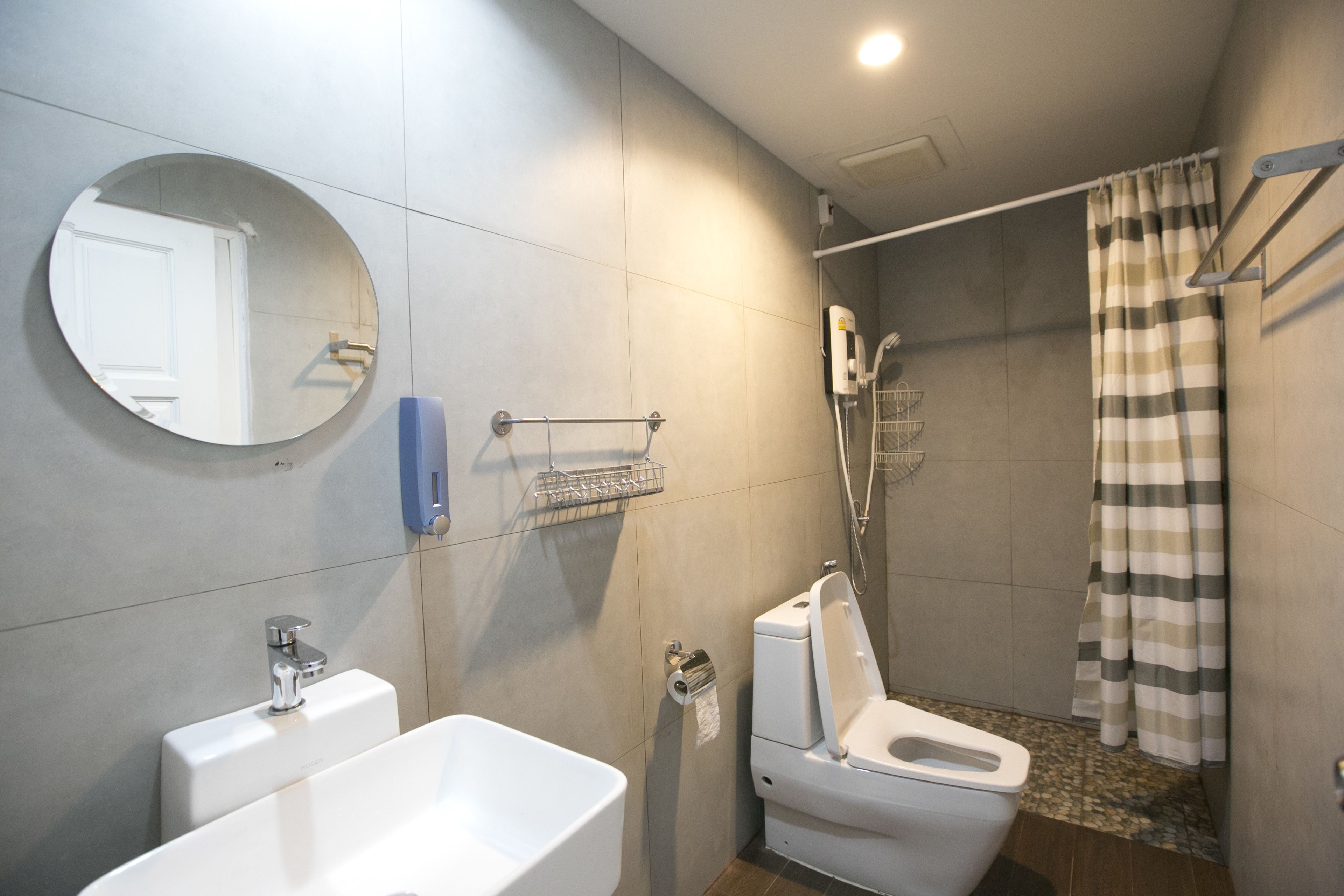 Un baño moderno con inodoro, lavabo y ducha.