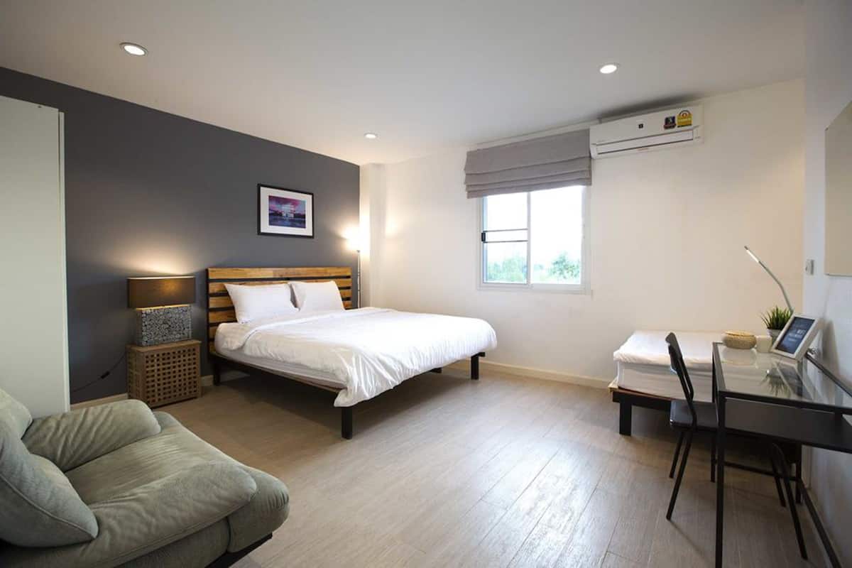 Ein modernes Schlafzimmer mit einem Bett, einem Schreibtisch und einem Stuhl.