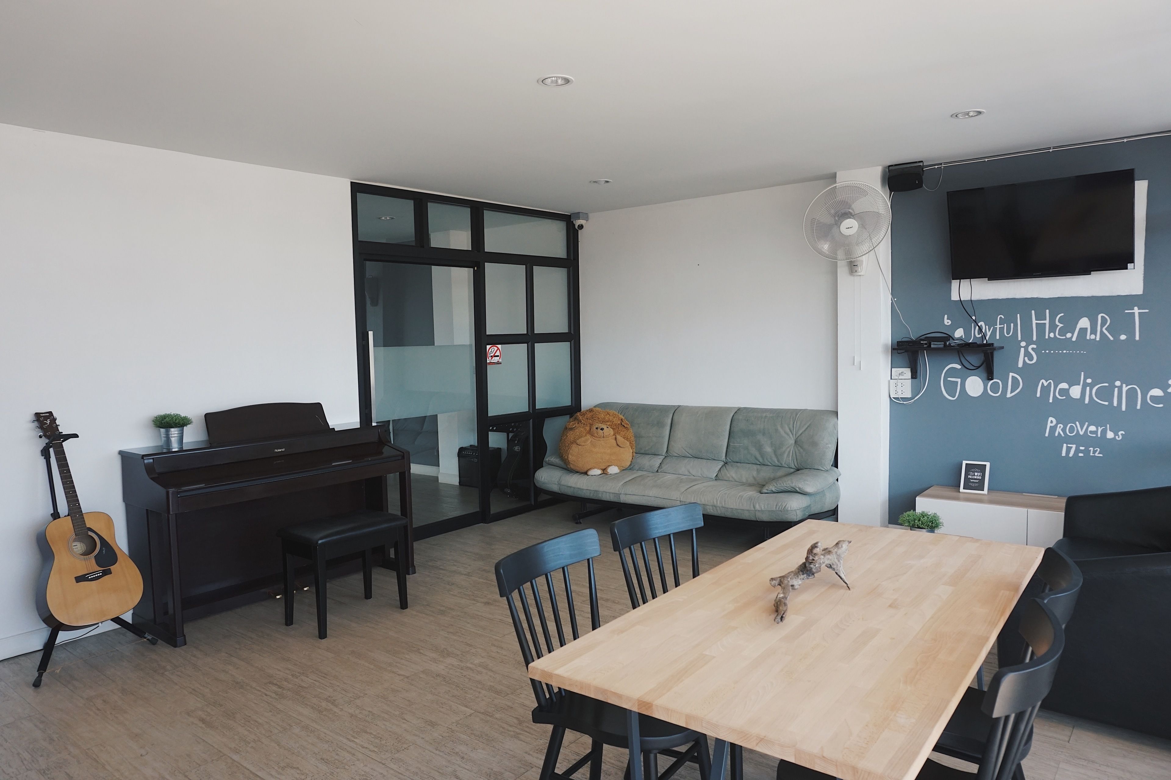 Una sala de estar moderna con un piano, una mesa de comedor y un sofá.