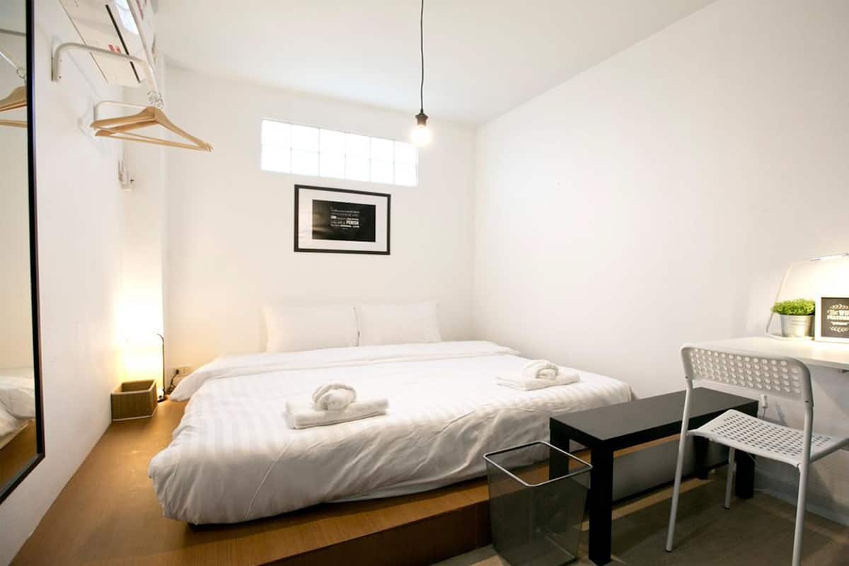 Ein modernes Hotelzimmer mit einem großen Bett, einem Schreibtisch und einem Stuhl.