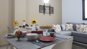 Un comedor con una mesa dispuesta para dos personas, un sofá y un adorno en la pared.