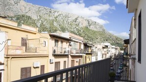 Una calle estrecha flanqueada por edificios, con una montaña al fondo y cielo despejado.