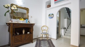 Una habitación con un armario de madera, una silla, un espejo y una escalera.