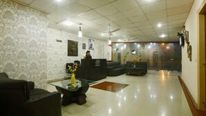 A reception area with a reception desk, seating, and decorative elements. - Hotel Green Lotus Dwarka (New Delhi)