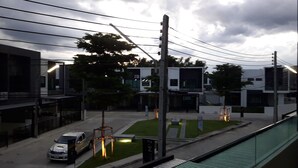 A modern building with a flat roof, a parking area, and a street with cars. - New Loft Modern Home (Hang Dong)