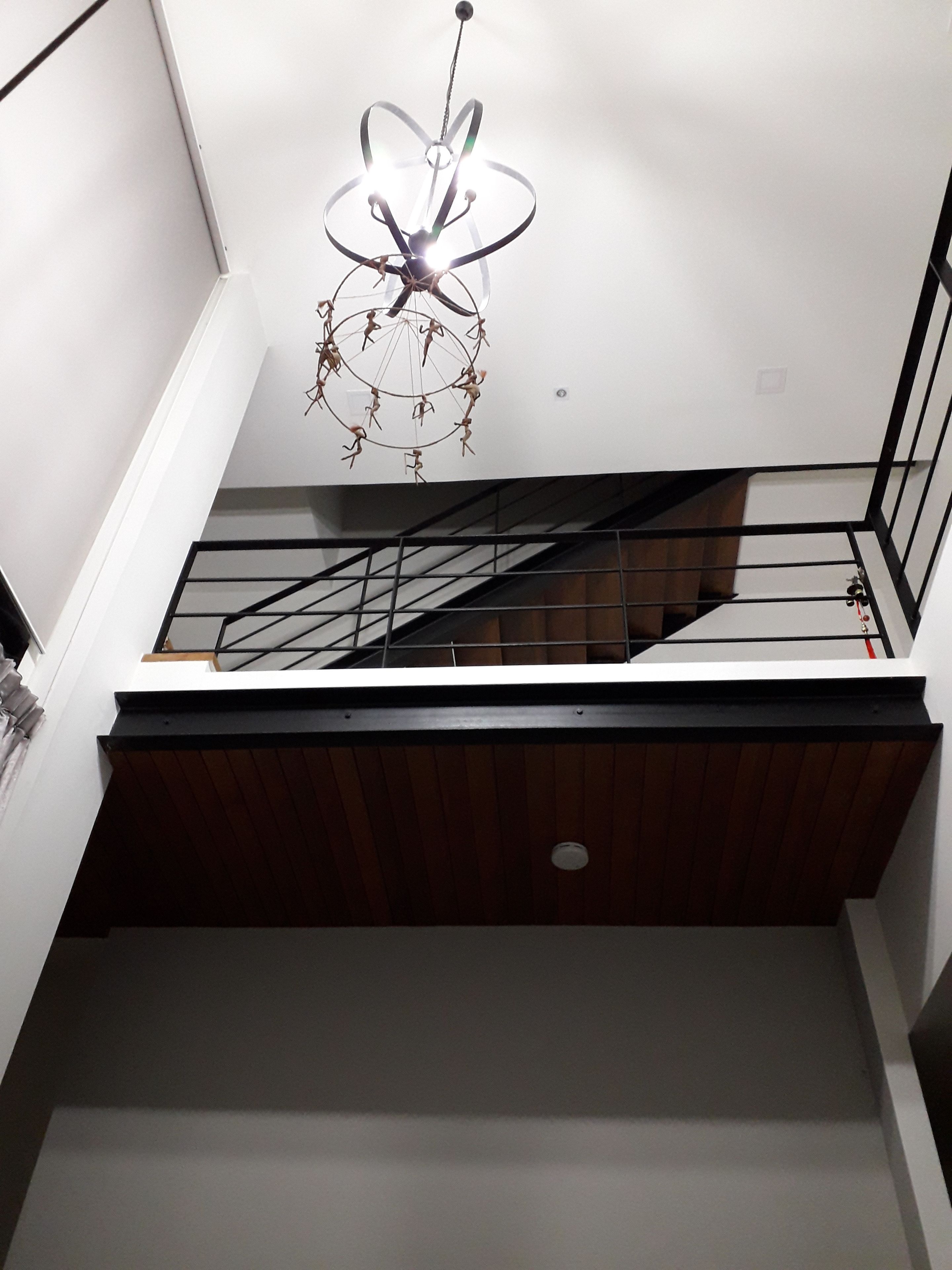 Una escalera moderna con detalles de madera y barandas de metal que conduce a un piso superior.