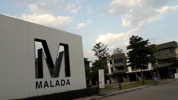 A modern building with a large 'M' and 'MALADA' sign, indicating a commercial or office space. - New Loft Modern Home (Hang Dong)