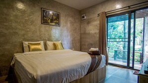 A bedroom with a large bed, a view of greenery through a window, and a painting on the wall. - Long Lake Resort (Si Racha)