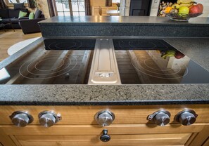 A kitchen with a BORA induction cooktop, wooden cabinets, and a granite countertop. - Apartment 2 - Ground floor - Apartment Tegernsee, Family Schneider, Kreuth (Kreuth)