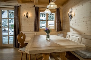 A wooden interior with a large table, benches, and a vase of flowers. - Apartment 2 - Ground floor - Apartment Tegernsee, Family Schneider, Kreuth (Kreuth)