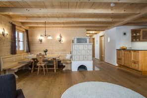 Un intérieur en bois comprenant un coin repas, une cheminée et une cuisine.