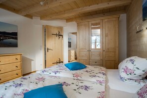 Une chambre à coucher avec un lit, une armoire en bois et un tableau accroché au mur.