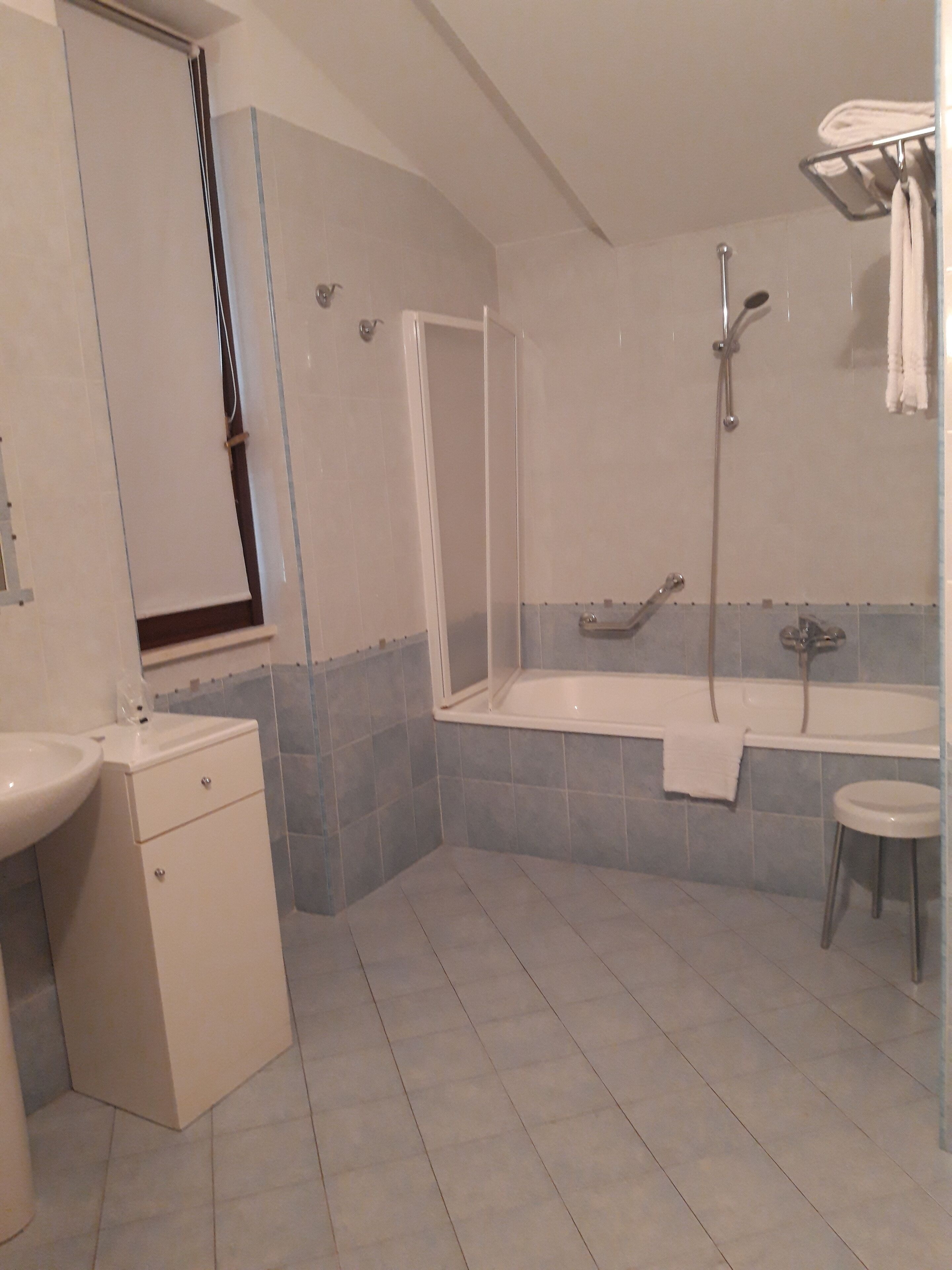 A modern bathroom with a shower, bathtub, and two sinks.