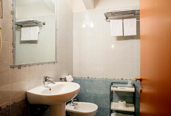 Une salle de bain équipée d’un lavabo, d’un bidet et d’un porte-serviettes.