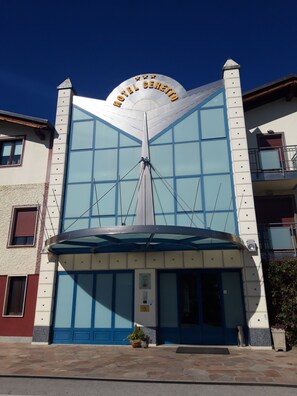 Un hôtel au design moderne et original, caractérisé par une grande façade vitrée et une enseigne bien visible indiquant « HÔTEL CERETON ».