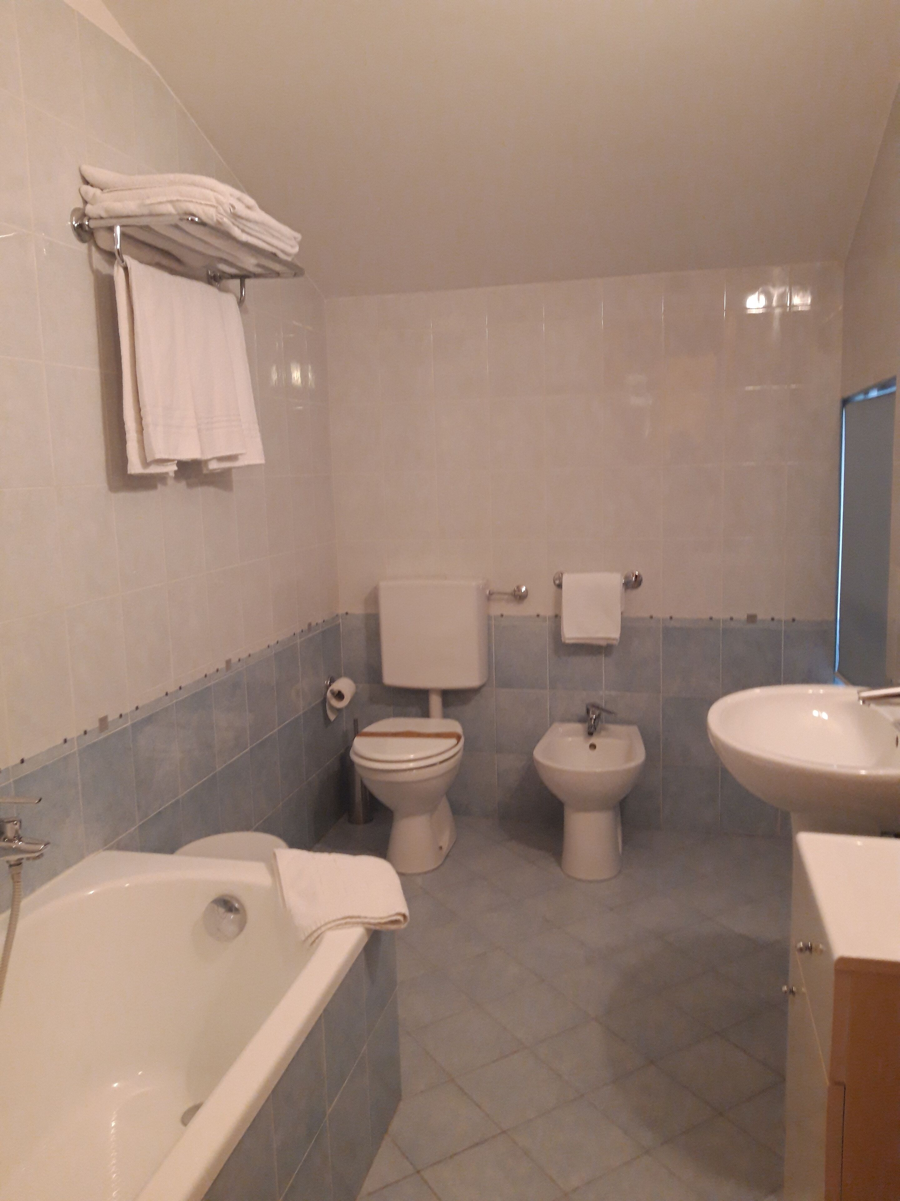 A bathroom with a bathtub, toilet, bidet, and sink.